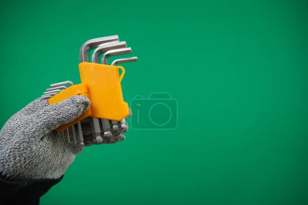 Photo for Set of hex keys in hand on green background advertising Green background chromakey free space - Royalty Free Image
