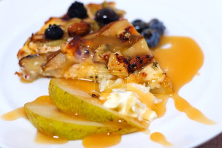 tart with pear and cheese. High quality Puff pastry tart with pears, blue cheese and pecan nuts Mini tarts with puff pastry, pieces of pear, blue cheese, walnuts and honey on a concrete background.