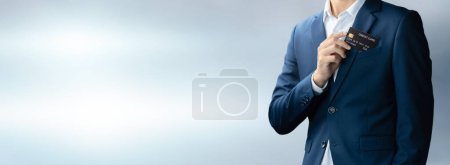 Photo for Businessman in blue suit put or take out credit card in pocket with copy space background, Technology digital future of business finance and payment online shopping concept, Handsome young in close up - Royalty Free Image