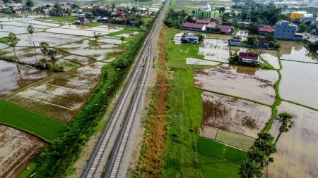 Vista de las vías férreas y campos de arroz en el campo, Pangkep, Indonesia