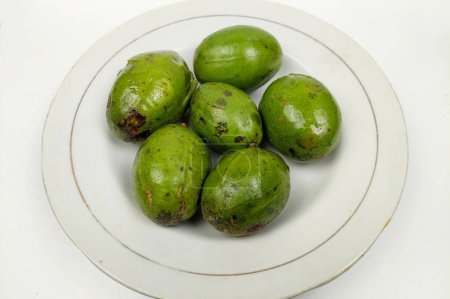Kedondong est également connu sous le nom de fruit ambarella ou pomme otaheite ou prune chaude, qui est délicieux sur une assiette blanche sur une table en bois.