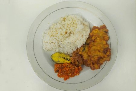 Rice mixed with fried fish and tempeh vegetables on a white plate