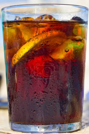 Photo for Cola glass with ice and lemon on a table: close up - Royalty Free Image