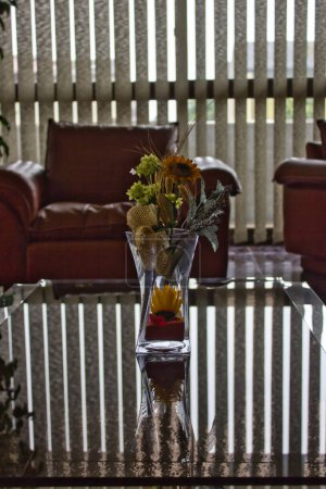 Téléchargez les photos : Vase en verre avec des fleurs sèches sur une table, en arrière-plan l'ombre des rideaux - en image libre de droit