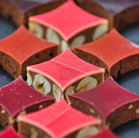 Foto de Macro fotografía de deliciosos cuadrados de chocolate de colores con nueces, listo para ser el regalo perfecto de San Valentín - Imagen libre de derechos