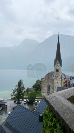 Photo for Old church Hallstatt Austria city view landscape background wallpaper vertical lake cloudy weather - Royalty Free Image