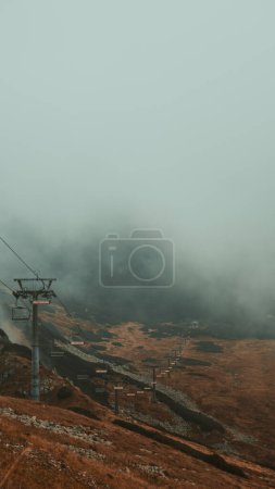 Photo for Ascending through the mystical veil of fog, where mountains whisper secrets and chairlifts paint the canvas of tranquility. - Royalty Free Image