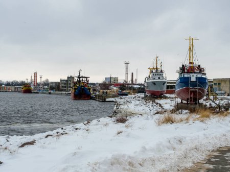 Bravant le froid d'une froide journée d'hiver, les bateaux de pêche se reposent le long de la côte de Ventspils, leurs coques colorées contrastant avec le fond neigeux, un témoignage de l'esprit durable de la vie maritime dans la Baltique.