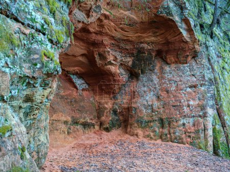 From afar, the red cliffs of Cesis appear as a fiery beacon, drawing travelers to their rugged slopes and majestic peaks