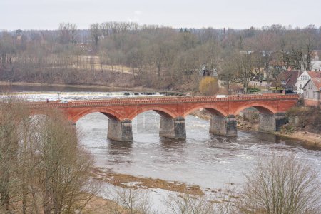 Téléchargez les photos : Plongez-vous dans le romantisme du pont de briques rouges de Kuldiga, où chaque brique raconte une histoire et chaque arche conserve un souvenir - en image libre de droit