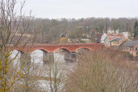 Téléchargez les photos : Ressentez le poids de l'histoire sous vos pieds en traversant le pont en brique rouge de Kuldiga, un point de repère intemporel du patrimoine letton - en image libre de droit