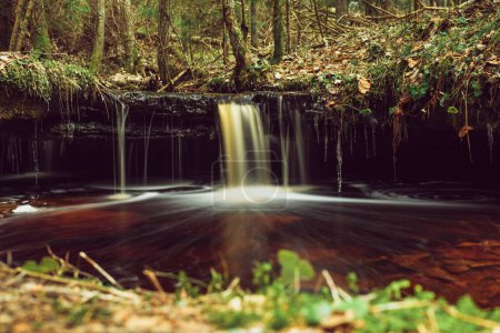 La fotografía de larga exposición revela la serena elegancia de Olupite Waterfall, un símbolo atemporal del desierto virgen de Letonia