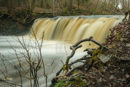 In der zeitlosen Umarmung der langen Belichtungszeit verströmt Ivandes Wasserfall eine Aura von Magie und verzaubert alle, die seinen majestätischen Fluss in Lettlands Wildnis sehen..