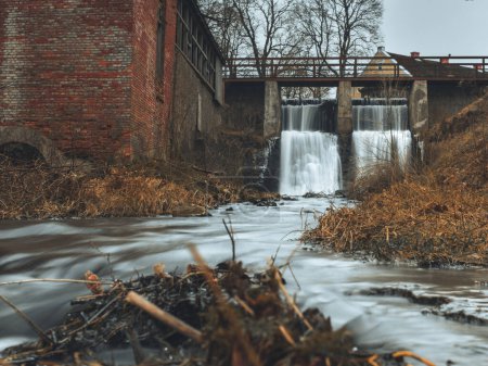 Sumérgete en la sinfonía de la naturaleza en Aleksupite Waterfall, donde el rugido rítmico del agua en cascada resuena a través de Kuldiga, Latvija