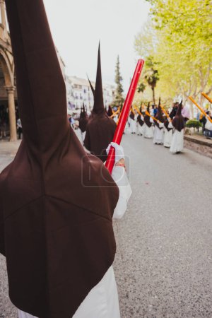 Photo for Holy Week procession with a Nazarene on his back carrying a large candle, Holy Week concept. - Royalty Free Image