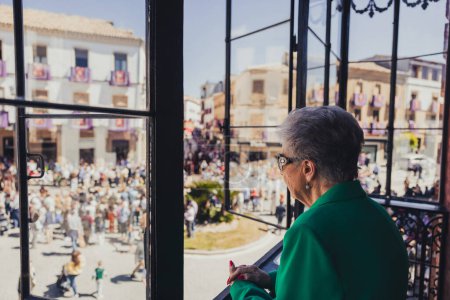 Photo for Woman watching Holy Week procession from her balcony, holy week concept - Royalty Free Image