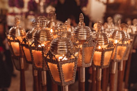 Téléchargez les photos : Lanternes allumées ensemble métalliques de la semaine sainte avec une croix sur le dessus et avec un bâton de bois - en image libre de droit