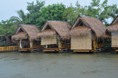 Foto de Casa tradicional de bambú en la orilla del río hace sentir cerca de la naturaleza - Imagen libre de derechos