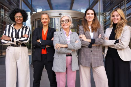 Photo for Five happy businesswomen standing side by side with their arms crossed. Suitable for team, friendship and diversity concepts. - Royalty Free Image