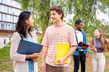 Photo for Multiracial gcollege homework and learning class lesson studying walking around the university campus. University life concept.roup of four happy teenage students talking with college notes. - Royalty Free Image