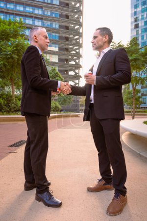 Foto de Socio para hacer que tus sueños crezcan juntos. Foto de dos hombres de negocios dándose la mano al aire libre - Imagen libre de derechos