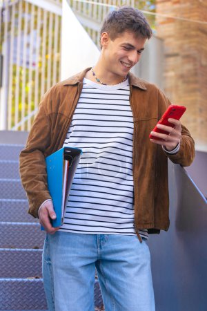 Photo for Young student typing on phone browsing mobile phone on social media while walking down stairs on university campus outdoors - Royalty Free Image
