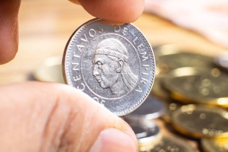 Foto de Dedos sosteniendo una moneda de honduras por valor de 50 centavos. - Imagen libre de derechos