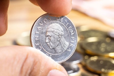 Foto de Dedos sosteniendo una moneda de honduras por valor de 50 centavos. - Imagen libre de derechos