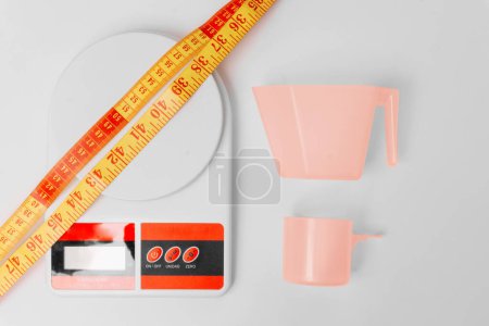 Photo for Zenith shot of kitchen scale, a meter and scoops over white background. - Royalty Free Image