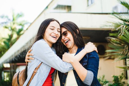 Téléchargez les photos : Portrait de deux jolies et souriantes jeunes femmes hispaniques se faisant un câlin tout en riant. concept d'amitié. - en image libre de droit