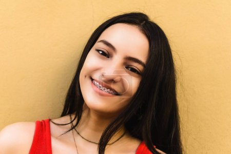 Foto de Retrato de una joven hispana feliz y hermosa oliendo entre paréntesis, concepto odontológico - Imagen libre de derechos