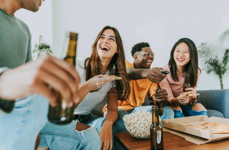 Téléchargez les photos : Jeunes gens joyeux multiraciaux ayant week-end fête à la maison ensemble. Des étudiants heureux qui s'amusent dans les chambres universitaires - en image libre de droit