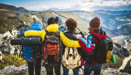 Téléchargez les photos : Heureux amis avec des sacs à dos ayant week-end de trekking ensemble. Concept sport, voyage et randonnée - en image libre de droit