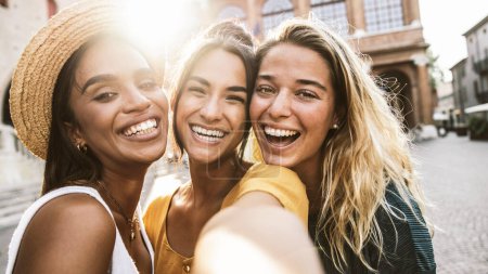 Téléchargez les photos : Photo de femmes multiraciales souriant à la caméra dehors. Concept d'amitié et de tourisme avec les filles s'amuser ensemble - en image libre de droit