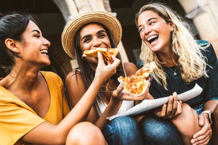 Photo for Three women eating pizza slice on city street. Happy lifestyle and tourism concept - Royalty Free Image