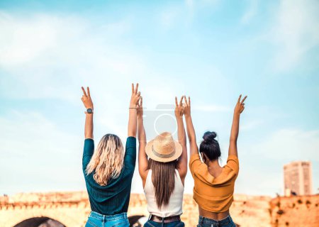 Téléchargez les photos : Des femmes heureuses les bras en l'air. Les gens qui soutiennent la communauté. Tourisme, voyage, concept de liberté et d'amitié - en image libre de droit