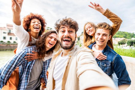Téléchargez les photos : Jeunes gens divers célébrant rire ensemble à l'extérieur. Concept de mode de vie heureux. - en image libre de droit