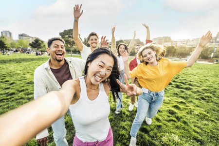 Foto de Millenial personas disfrutando del día de verano en el parque - Concepto de estilo de vida con chicos y chicas colgando al aire libre - Imagen libre de derechos