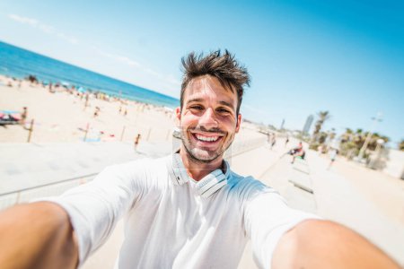 Foto de Joven tomar foto selfie con dispositivo inteligente - Feliz turista tomar una foto de sí mismo fuera en la playa disfrutando de vacaciones día de verano - Imagen libre de derechos