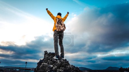 Téléchargez les photos : Homme les bras levés célébrant au sommet des montagnes - Randonneur jouissant de la liberté sur une colline au coucher du soleil - Liberté, sport, succès et santé mentale concept - en image libre de droit