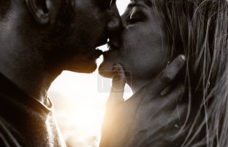 Foto de Pareja enamorada besándose al atardecer - Novio y novia abrazándose al aire libre - Dos amantes teniendo una cita romántica - Filtro blanco y negro - Concepto de fondo de amor - Imagen libre de derechos