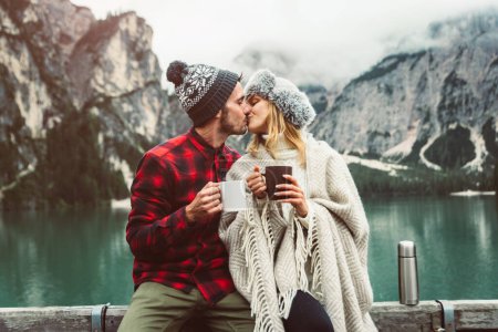 Téléchargez les photos : Baiser romantique d'un couple d'adultes visitant un lac alpin à Braies Italie. Touriste amoureux passer des moments d'amour ensemble dans les montagnes d'automne. Couple, désir ambulant et concept de voyage. - en image libre de droit