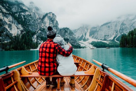 Téléchargez les photos : Couple romantique sur un bateau visitant un lac alpin à Braies Italie. Touriste amoureux passer des moments d'amour ensemble dans les montagnes d'automne. Concept de voyage, couple et errance. - en image libre de droit