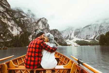 Foto de Beso romántico de un par de adultos visitando un lago alpino en Braies Italia. Turista enamorado pasar momentos de amor juntos en las montañas de otoño. Pareja, vagabundeo y concepto de viaje. - Imagen libre de derechos