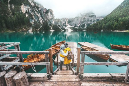 Foto de Senderistas que visitan el Lago Braies alpino italiano - Pareja enamorada disfrutando de impresionantes vistas del Lago di Braies en Dolomitas, Tirol del Sur, Italia, Europa. - Imagen libre de derechos