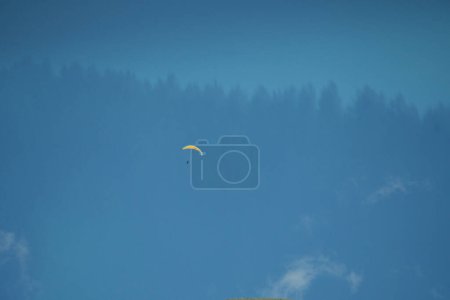 Photo for A lone paraglider soars high above the Swiss Alps, embracing the freedom of the skies in Switzerland's breathtaking mountain landscape. - Royalty Free Image