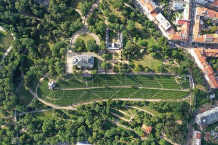 Photo for An aerial drone view reveals a serene Havlickovy Sady green park with a central amphitheater in the heart of Prague, highlighting the city's commitment to green spaces and cultural venues. The layout of the park offers a natural retreat and a space f - Royalty Free Image
