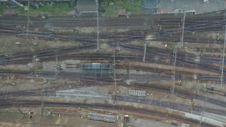 Photo for The drone image captures the complex web of railway lines at a junction in Prague, showing the intricate patterns formed by the tracks. The detailed aerial view highlights the transportation network's engineering, with tracks crisscrossing and trains - Royalty Free Image