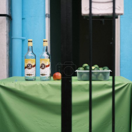 Photo for Captured behind the bars of a local establishment, two bottles of cachaca, Brazil's traditional spirit, sit alongside fresh limes, ready to be transformed into the country's signature caipirinha cocktail. - Royalty Free Image