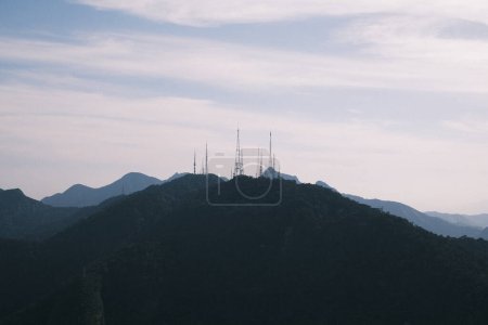 Photo for The distant radio towers stand as silent sentinels on the mountain ridge, overlooking the vast landscape of Rio de Janeiro. This tranquil scene highlights Brazil's blend of technology and nature, where human innovation meets the timeless beauty of th - Royalty Free Image